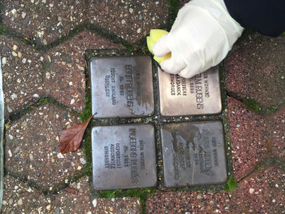 Schüler*innen reinigen die Stolpersteine in Herzogenrath