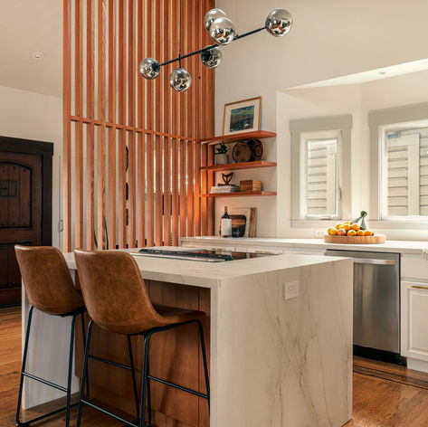 Waterfall island with leather stools beside the slatted wood screen