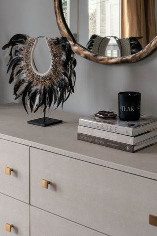 Modern bedroom shagreen dresser styled with Balinese necklace, design books and a candle.  