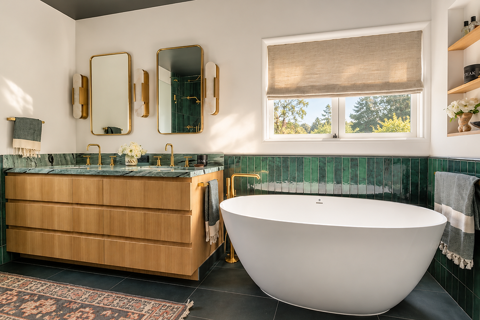Primary bath with oak vanity, freestanding tub, emerald tile and a patterned rug