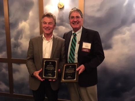 Two people standing with plaques