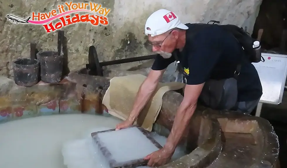 Dipping into the paper pulp to make a sheet of paper during Amalfi paper tour.