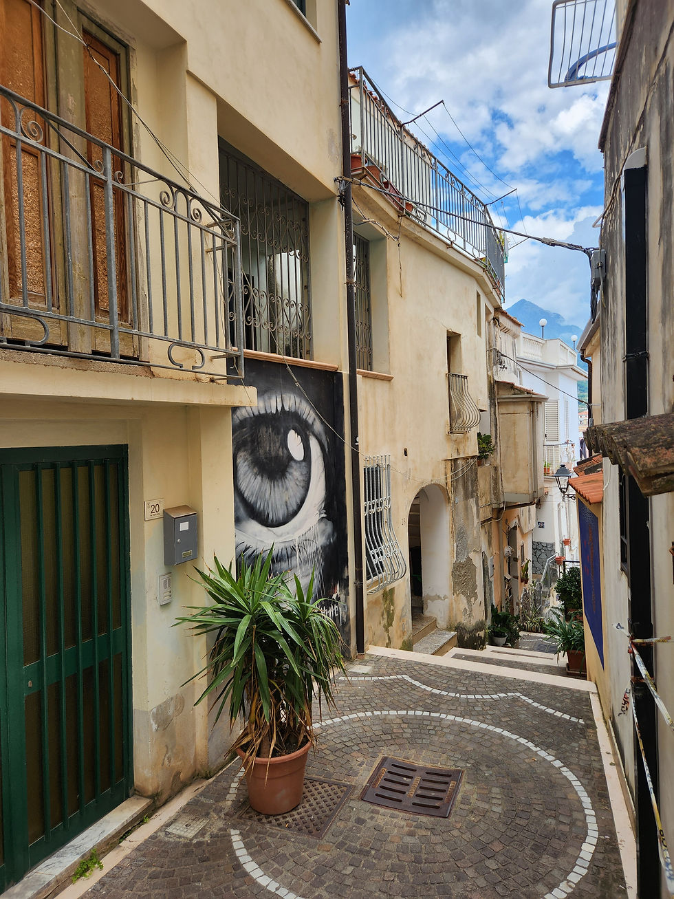 Alleyway in Diamante with large eye mural haveityourwayholidays