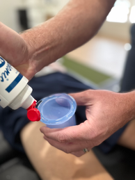 Integrative Physical Therapist placing gel on a cup to perform dry cupping on a patient with pain