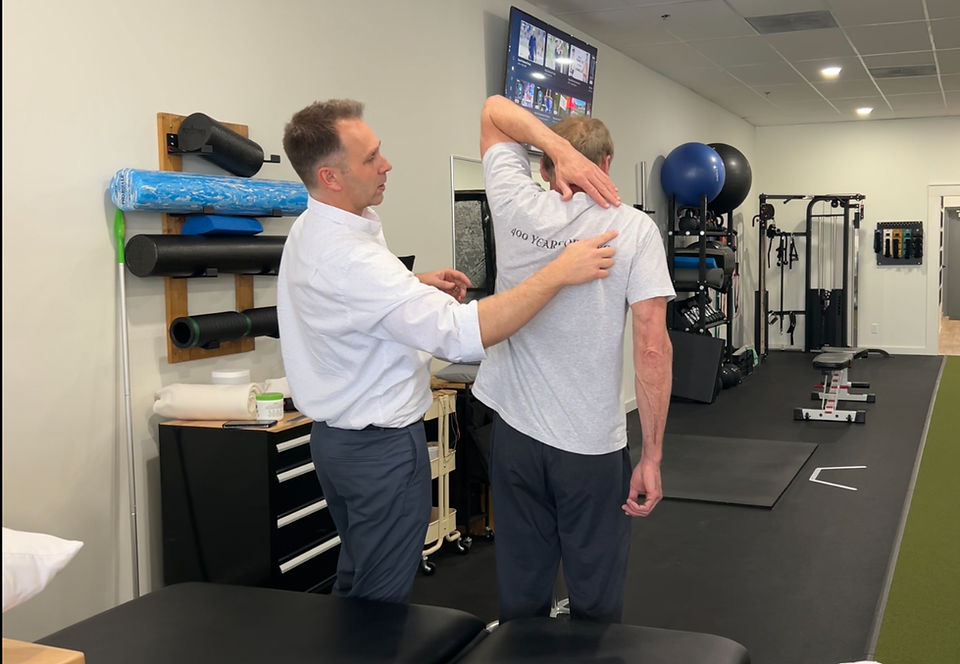 Integrative physical therapist performing an assessment to determine the root cause of the patient's shoulder pain