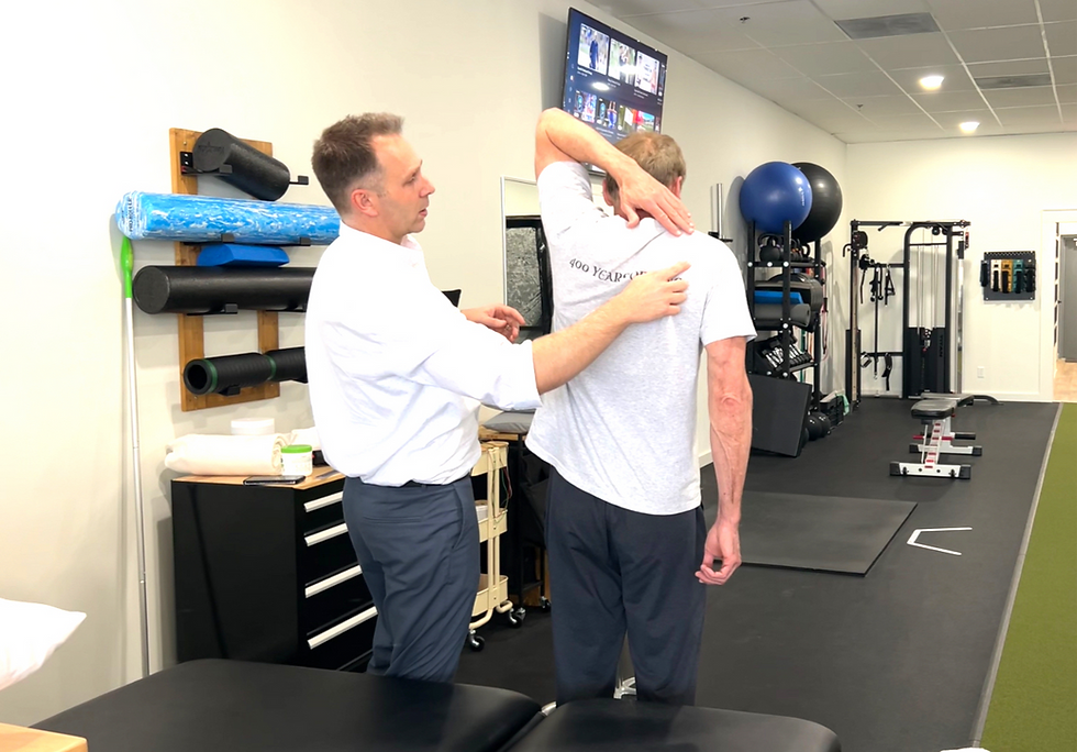Physical therapist performing a shoulder mobility assessment on a client with shoulder dysfunction.
