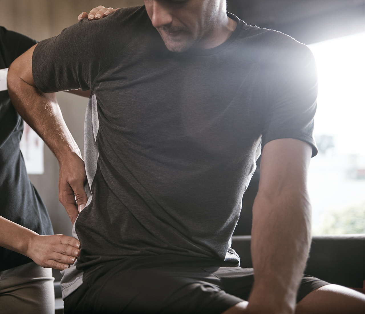 Person being evaluated for a low back injury, indicative of future injury when playing pickleball if not addressed correctly