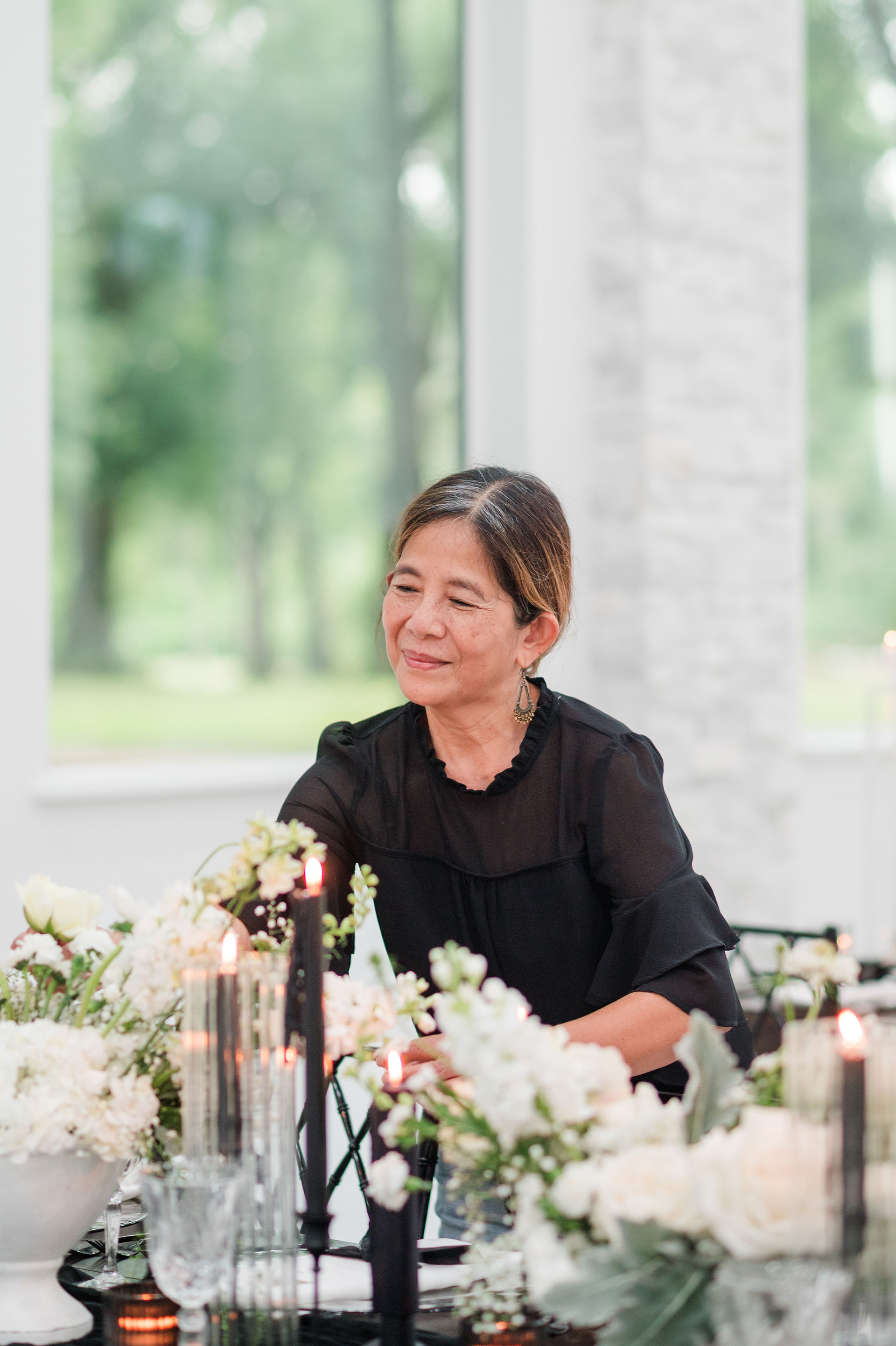 Orlando florist smiling as she finishes the centerpieces for a black and white styled wedding