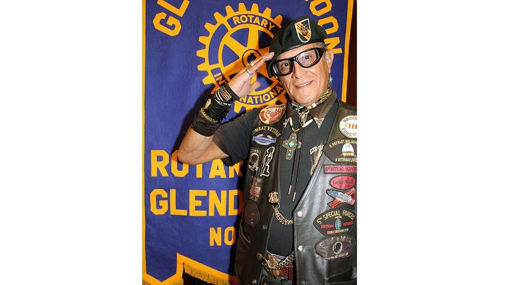 Albert Lynn "Lone Wolf" Boles smartly salutes the flag as he leads Glendale Noon Rotary members in the Pledge of Allegiance. (Ruth Sowby Rands / Glendale News-Press)