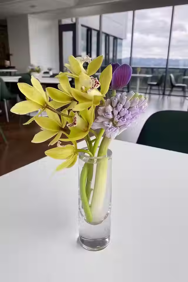 Yellow orchid and purple bud vase arrangement with a Portland skyline view