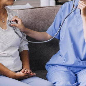 Home health nurse checking an elderly woman's blood pressure while providing in-home care and support.
