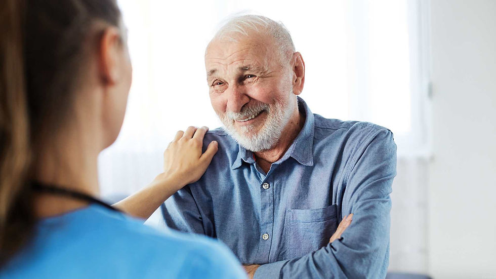 Compassionate home health caregiver providing support and companionship to an elderly man during an in-home care visit.