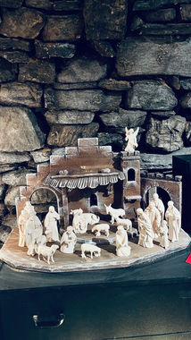 Detailaufnahme einer handgefertigten christlichen Krippe aus erzgebirgischer Holzkunst mit Maria, Josef und dem Jesuskind.