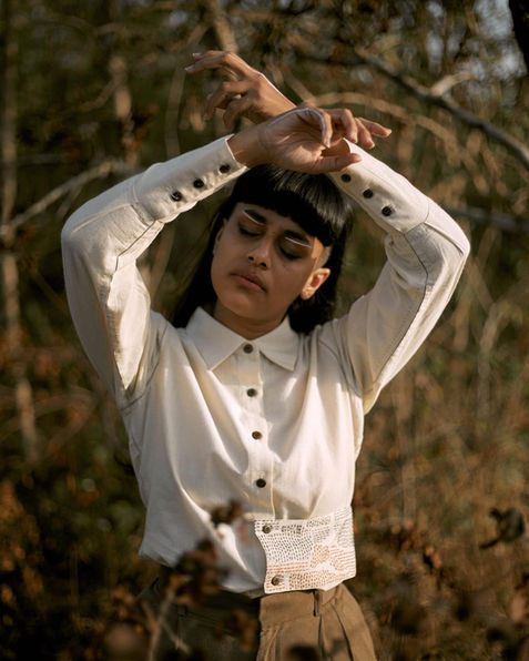 model poses with her arms crossed over her head