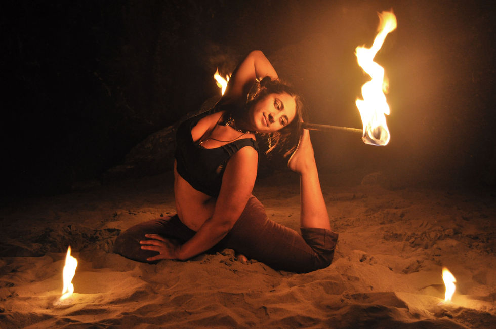 Beautiful woman in yoga pose with fire