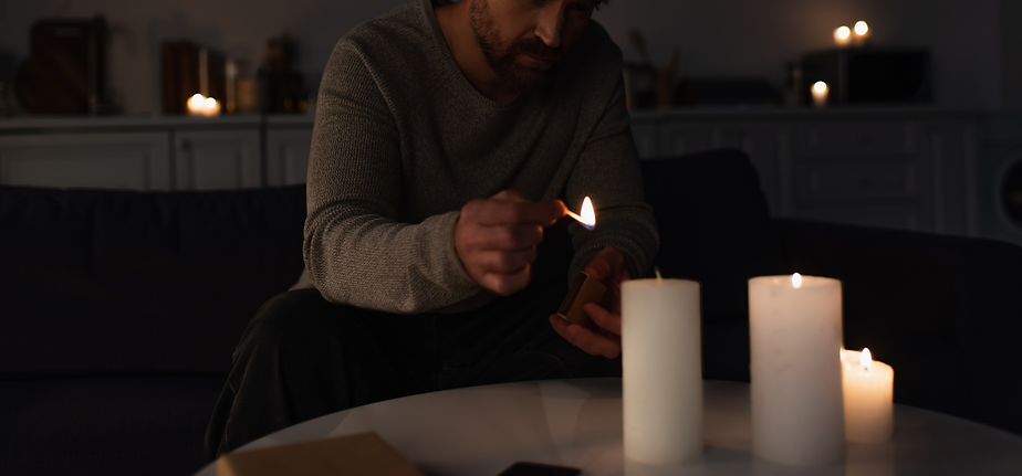 Man using candles to light his home during a power outage