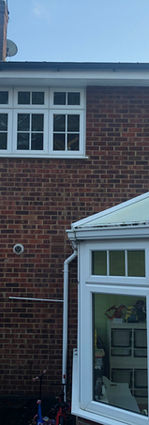 Close view of white uPVC conservatory on brick wall before extension.

