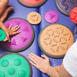 Therapist and child playing with textured tactile discs