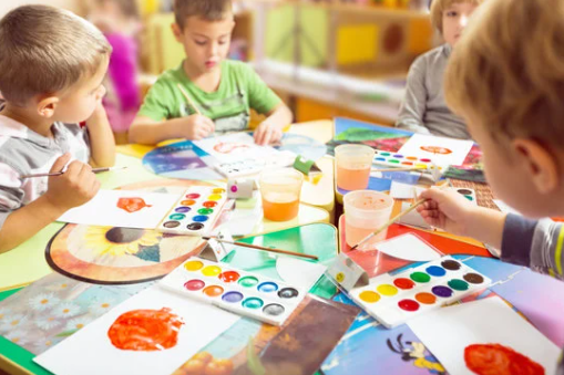 Preschool children painting at a table