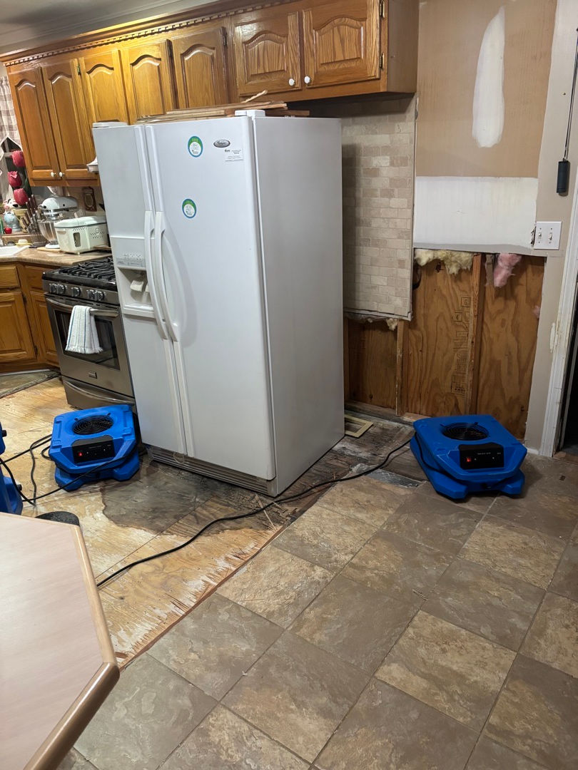 Eye-level view of water-damaged living room floor with warped wood and discoloration