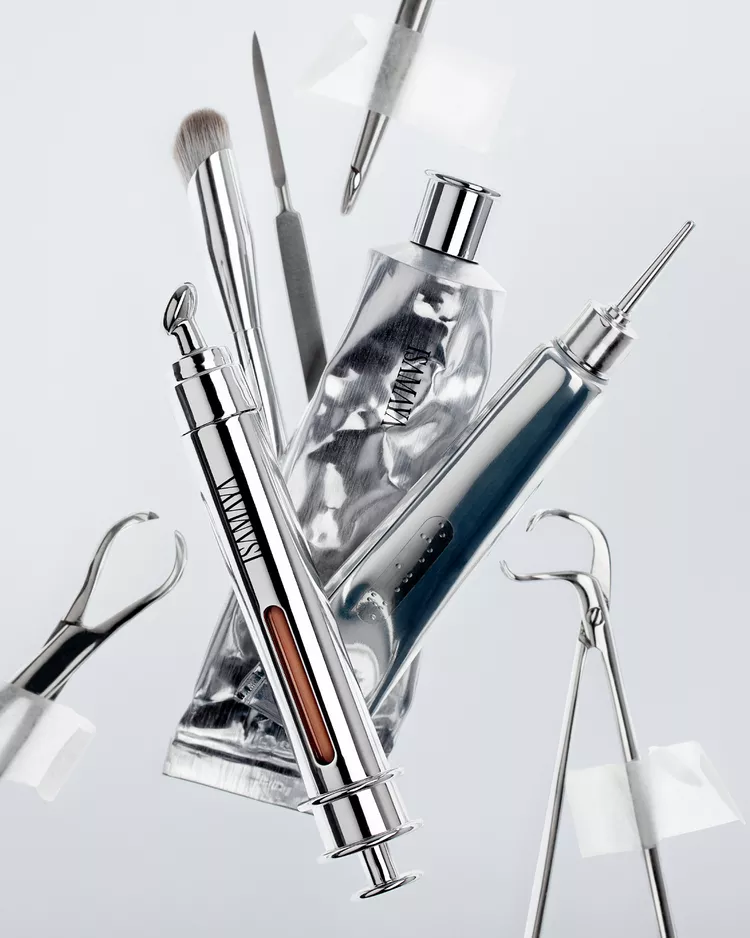 Conjunto de produtos de beleza prateados e tubetes metálicos flutuando em composição limpa e futurista.