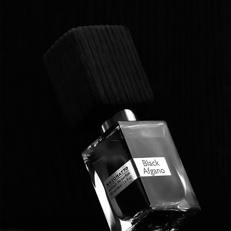 Frasco do perfume Black Afgano, da marca Nasomatto. O frasco de vidro transparente exibe líquido escuro e tampa grande em madeira preta texturizada, fotografado em fundo igualmente escuro, transmitindo intensidade, mistério e sofisticação.