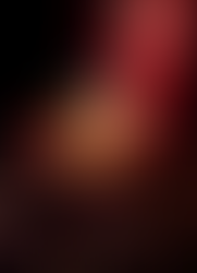 Frasco de cristal transparente do perfume No. 1 Imperial Majesty da Clive Christian, com um grande diamante branco na tampa e colar de ouro. O frasco está deitado em uma caixa de madeira polida forrada com veludo vermelho, que tem o brasão e o nome 'CLIVE CHRISTIAN' bordados na parte interna da tampa.