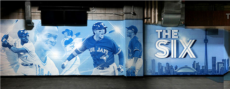 two blue jays baseball players are on a wall