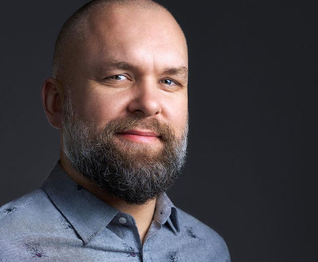 Portret headshot w stylistyce zdjęć wizerunkowych na ciemnym tle. Autor Fotograf Headshot - Jakub Strumiłło.