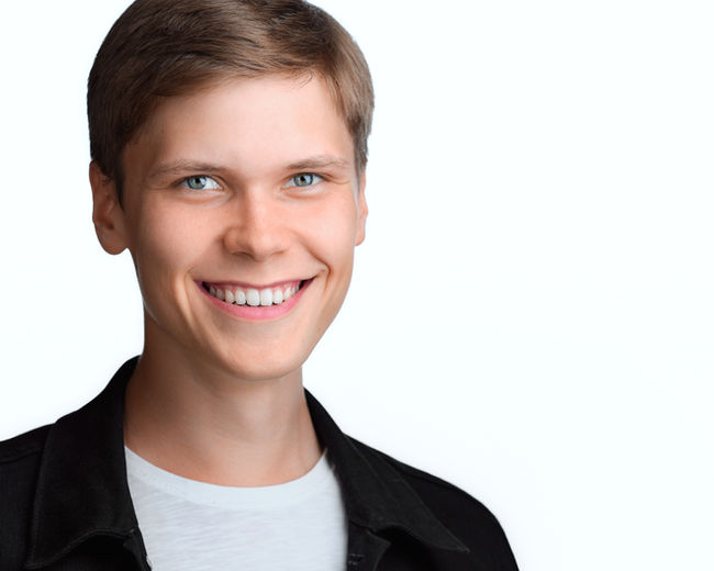 Jakub nowoczesny portret headshotowy na białym tle.