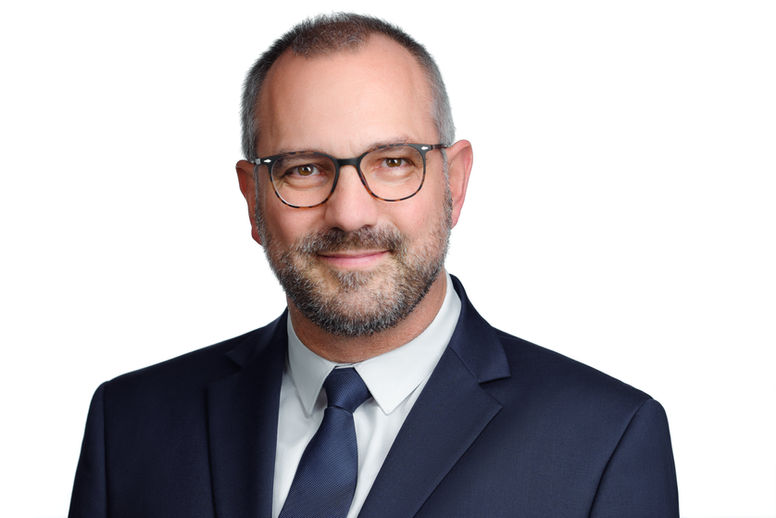 Karol nowoczesny portret biznesowy, w stylistyce headshotu wizerunkowego na białym tle.