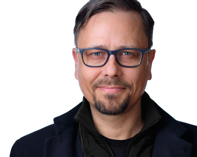 Nowoczesny portret headshotowy na białym tle. Profesjonalne zdjęcie wizerunkowe będące wynikiem świetnej sesji biznesowej.