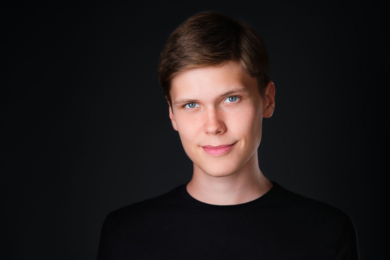 Portret headshot w stylistyce zdjęć wizerunkowych na ciemnym tle. Autor Fotograf Headshot - Jakub Strumiłło.