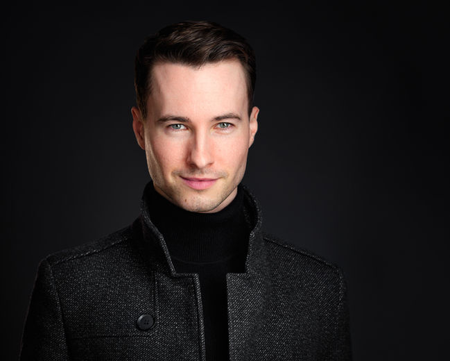 Portret headshot w stylistyce zdjęć wizerunkowych na ciemnym tle. Autor Fotograf Headshot - Jakub Strumiłło.