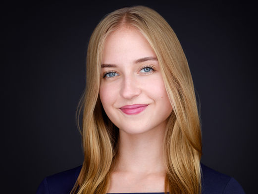 Julia, zdjęcie wizerunkowe na ciemnym tle. Charakteryzujące pięknym naturalnym uśmiechem.