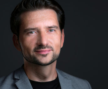 Portret headshot w stylistyce zdjęć wizerunkowych na ciemnym tle. Autor Fotograf Headshot - Jakub Strumiłło.