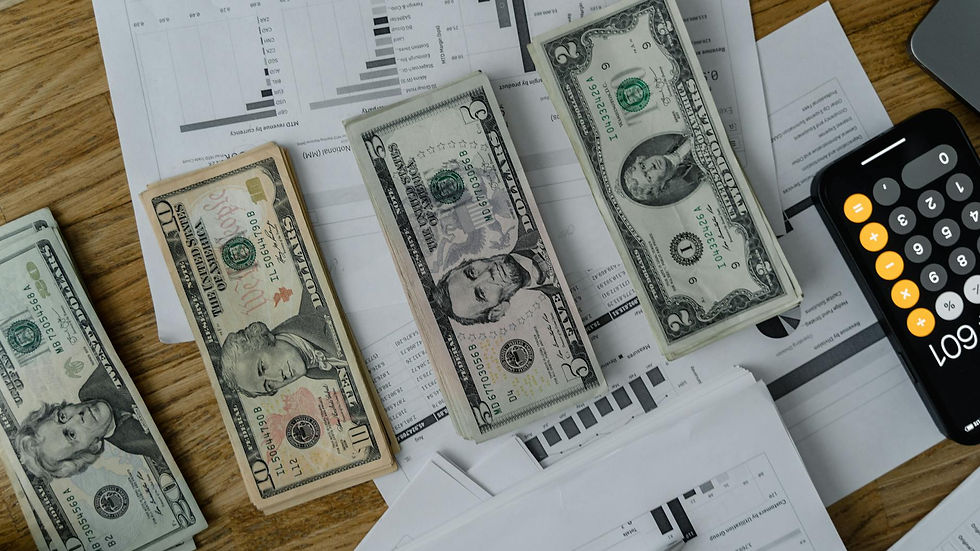 A workspace setup featuring cash, documents, and a calculator symbolizing financial analysis and budgeting.