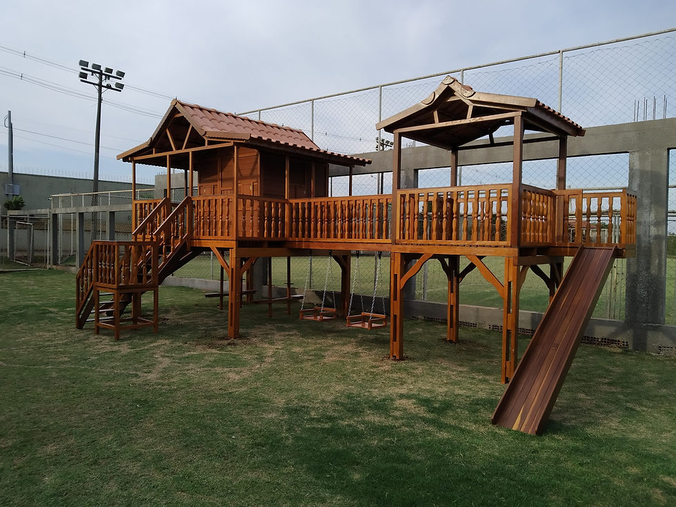 Playground em madeira envernizada em um quintal gramado