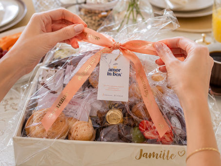 Cesta de café da manhã personalizada da Amor in Box sendo aberta, com o nome Jamiile na caixa, croissants, morangos, suco e café, pronta para presentear em João Pessoa.