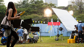 A woman walking by a film crew