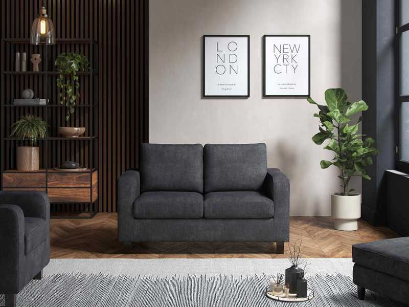 Thumbnail: Dark grey two-seater sofa, "LONDON" "NEW YORK CITY" posters, modern living room.