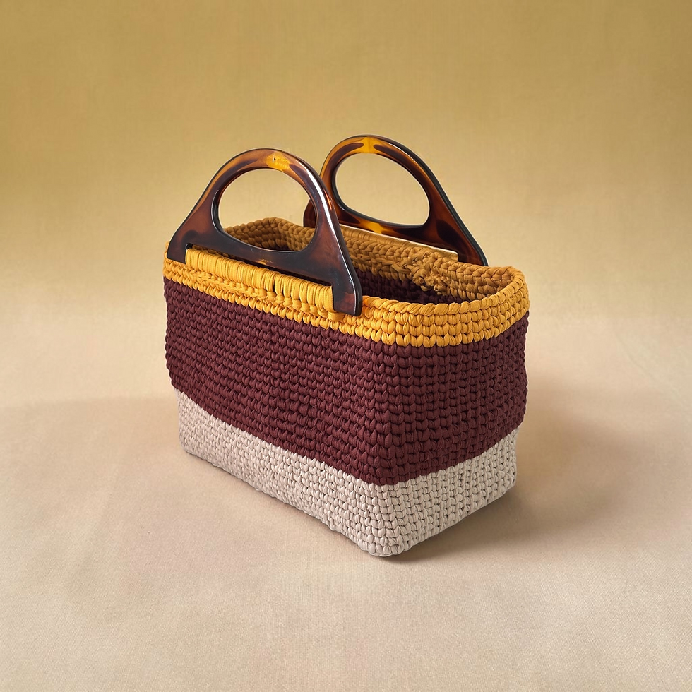 Bolsa feminina de crochê Odysée MD Création em ambiente sofisticado com acabamento artesanal e alça em acetato. Vista 3/4.