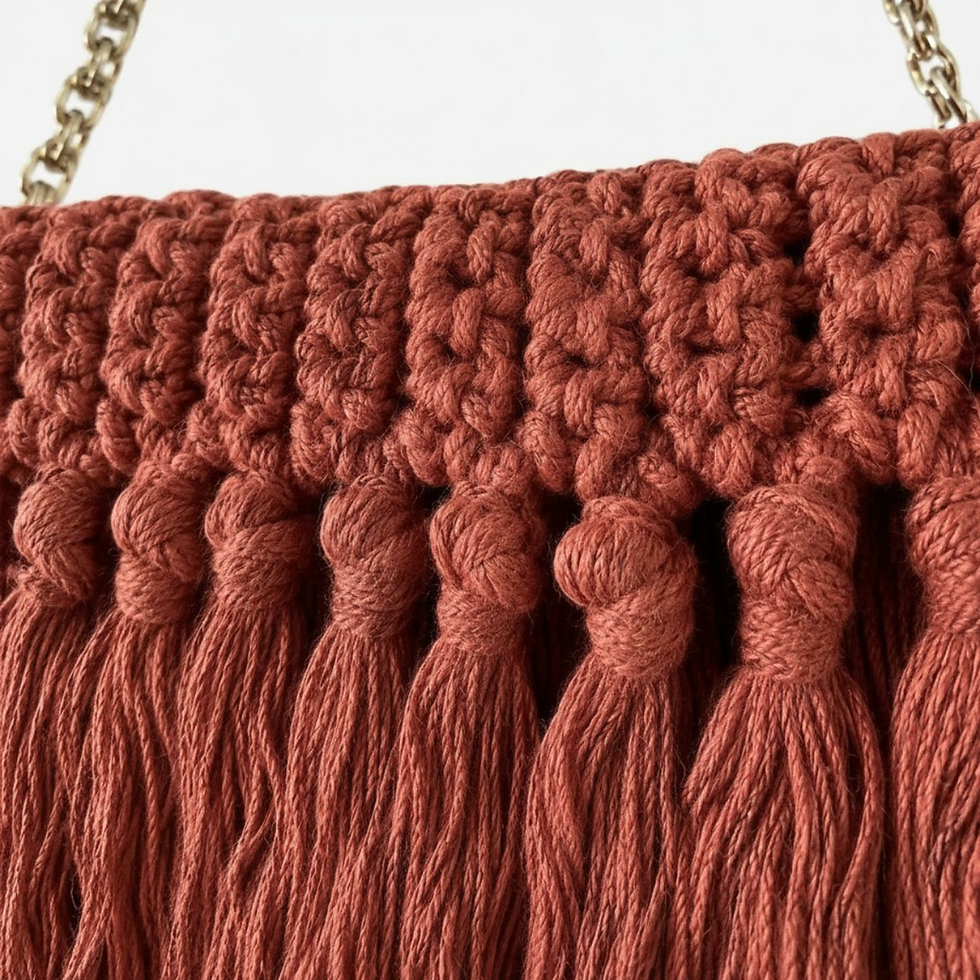 Miniatura: Detalhe da Clutch de crochê terracota Onde MD Création, com alça dourada e textura artesanal.