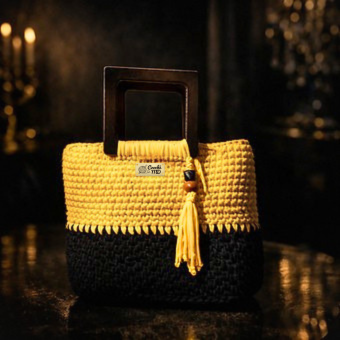 Miniatura: Bolsa de crochê amarela e preta Éclat MD Création com alça de madeira em ambiente noturno elegante