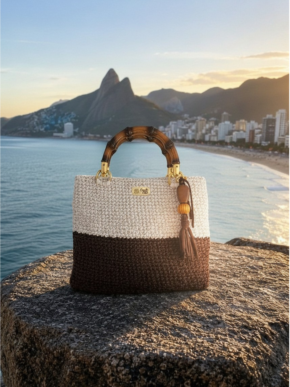 Miniatura: Bolsa feminina Dualité MD Création em crochê branco gelo e marrom café, sobre rocha à beira-mar.