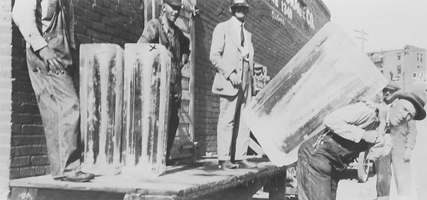 Man carries large block of ice on his back.