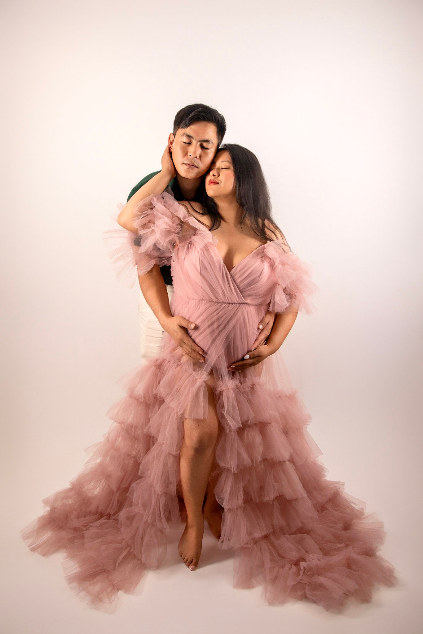 Elegant maternity portrait of expecting mother wearing a flowing gown