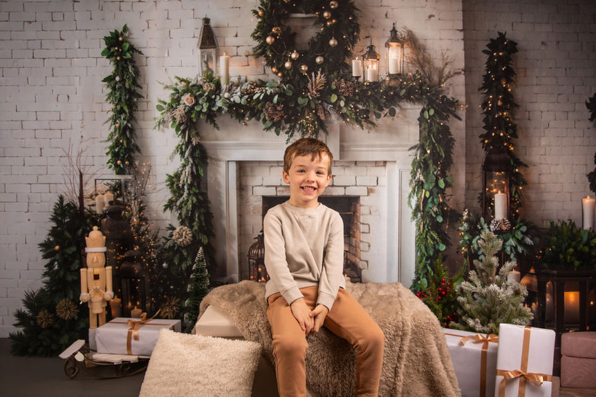 Candid moment of a child throwing fake snow in the air during a holiday session.