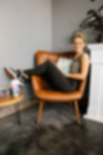Author, Tabitha Erbe, on a chair drinking tea
