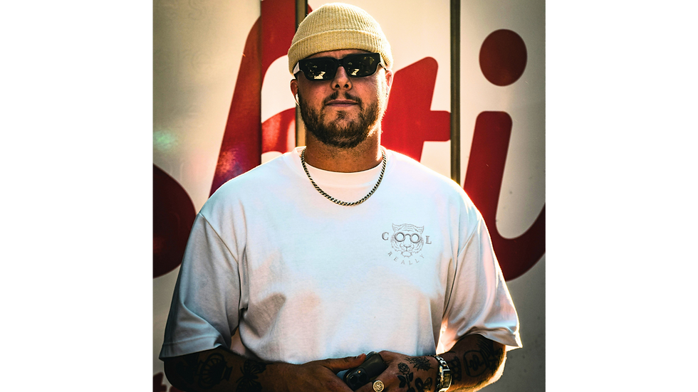 Model wearing the white REALLY COOL® VOID MX Signature 420 GSM tee with a subtle stealth logo in bright urban sunlight.